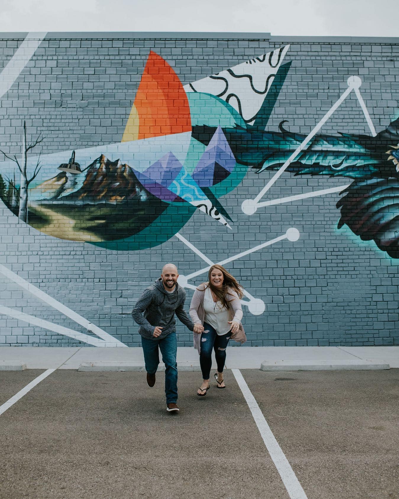 playful couple in front of mural